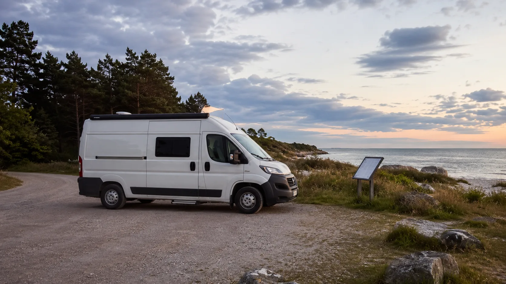 Plåtis på markerad grusparkering vid Gotlands kust i kvällsljus