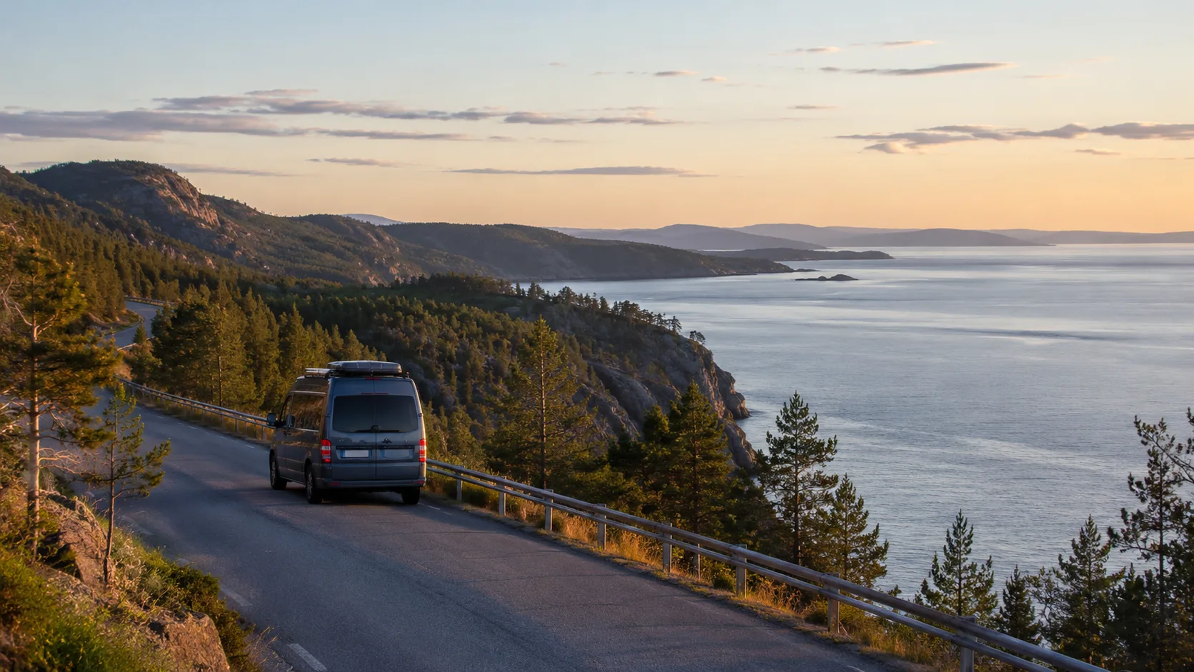 A van on a High Coast road with sea, forest and mountains in evening light