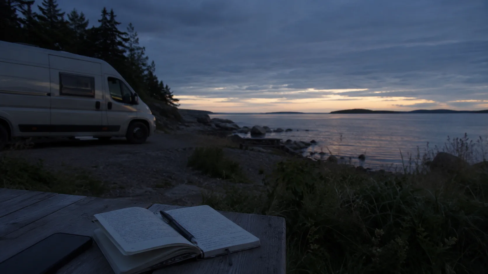 A motorhome at a coastal High Coast overnight place with a notebook in front