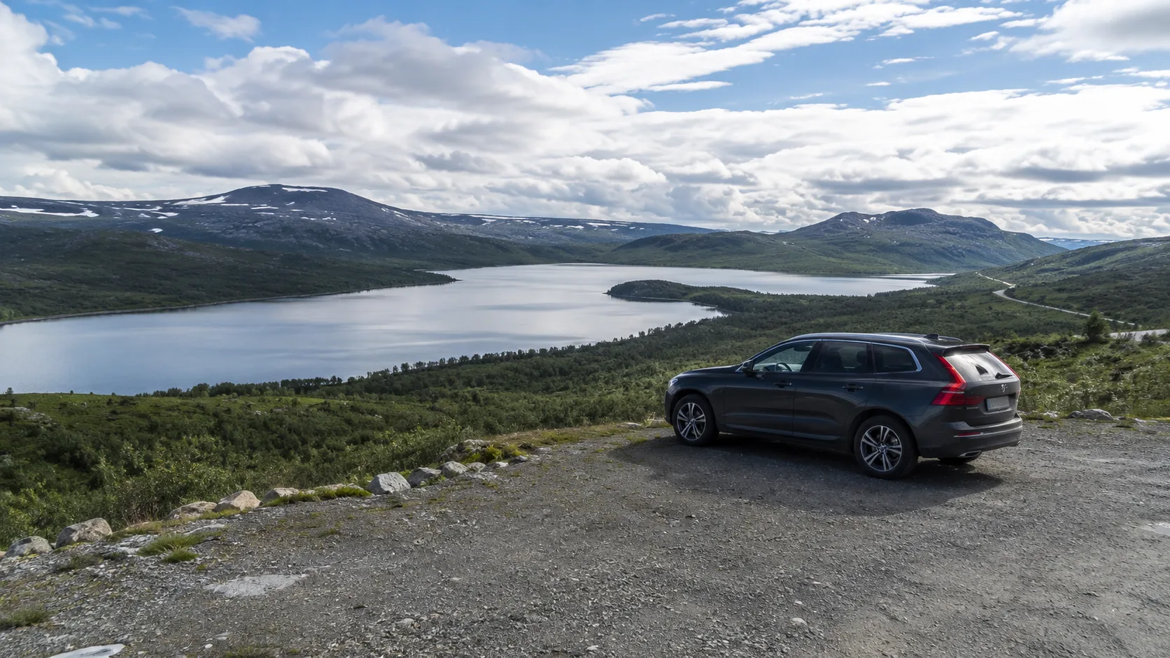 A car parked beside a mountain lake and view in Jämtland