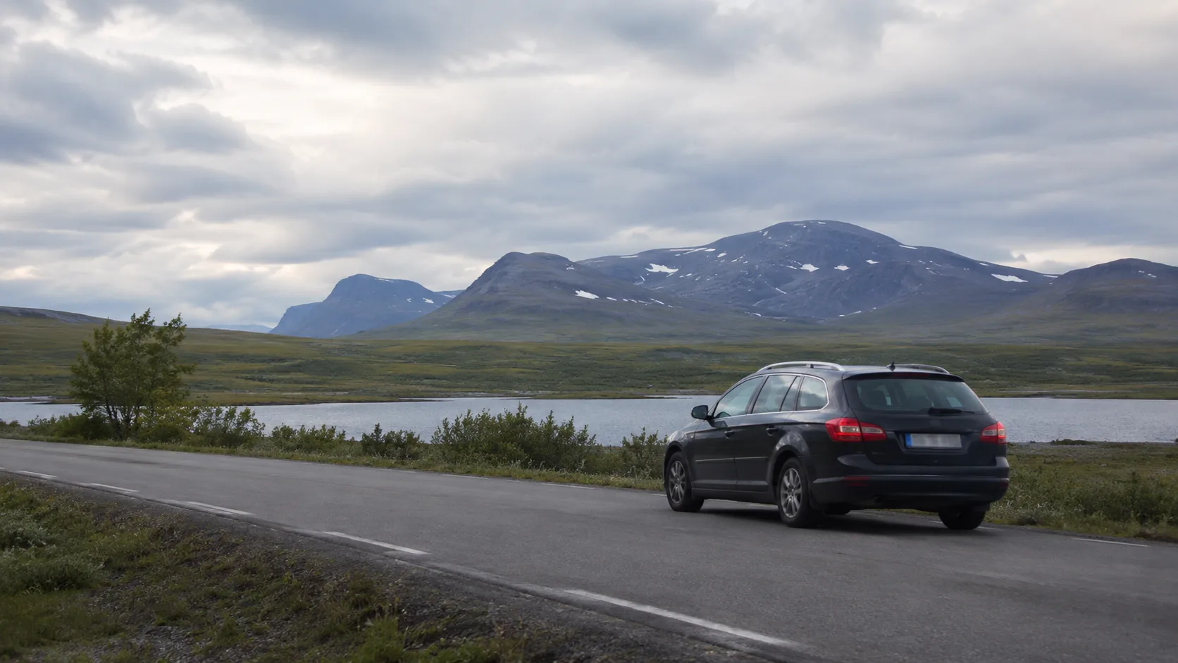 A car travelling through a northern Swedish mountain landscape