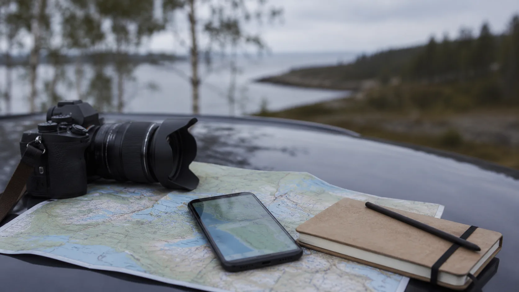 A map, phone, camera and notebook during a Norrbotten journey