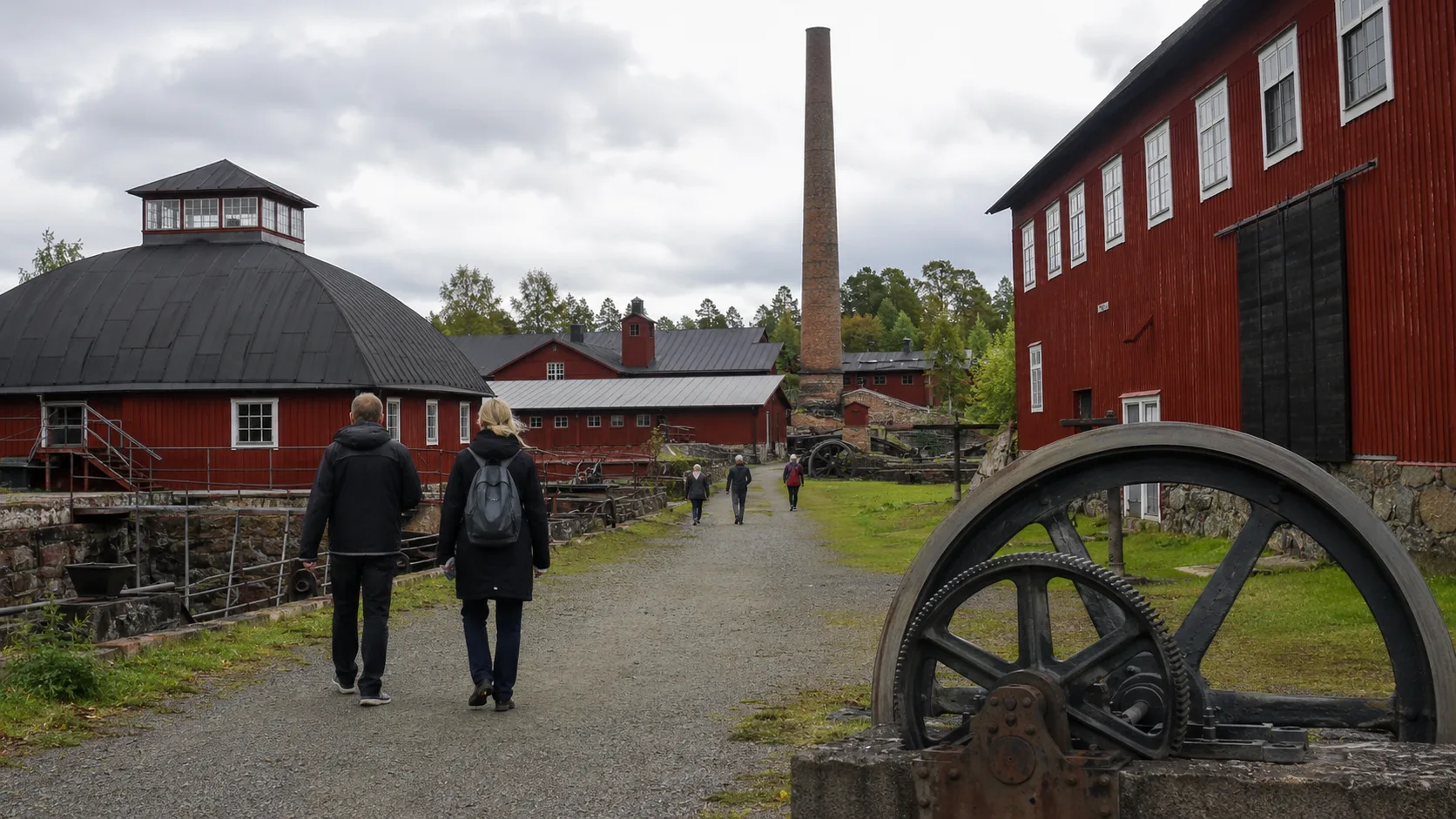 Visitors walking through the red industrial buildings at Engelsberg Ironworks